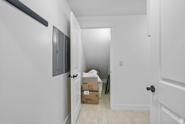 hall with electric panel, baseboards, and light tile patterned floors