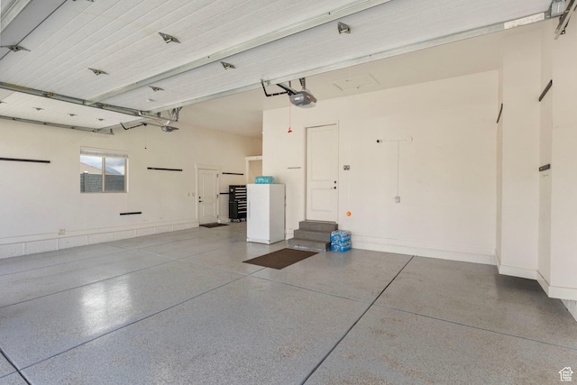 garage with a garage door opener and baseboards