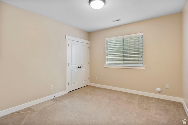 unfurnished bedroom with carpet, baseboards, and a closet