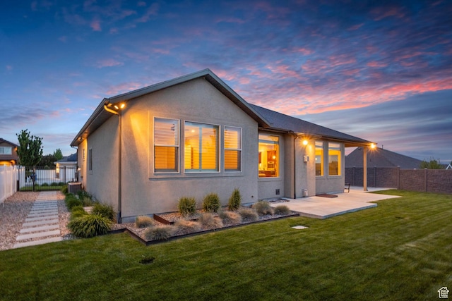 back of house at dusk with stucco siding, a patio, and central AC