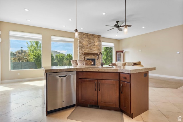 kitchen featuring stainless steel dishwasher, a sink, open floor plan, a stone fireplace, and recessed lighting