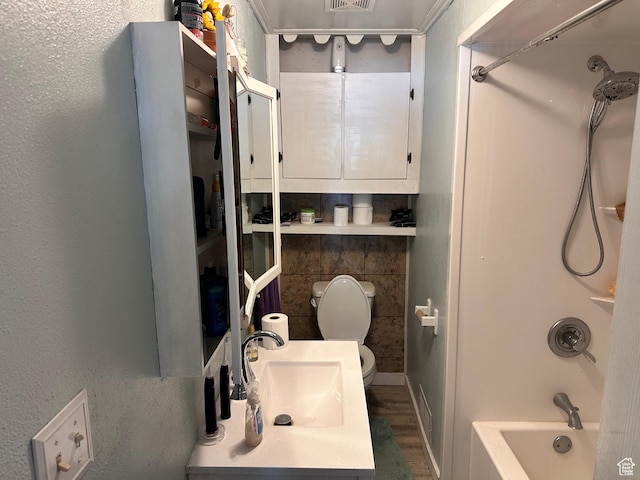 bathroom with a sink, toilet, bathing tub / shower combination, and wood finished floors