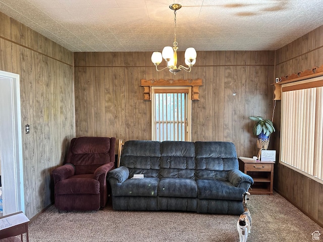 carpeted living area featuring a chandelier and wooden walls