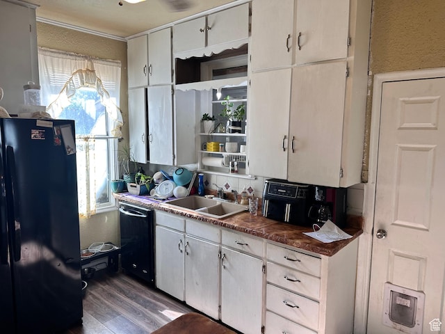 kitchen featuring black appliances, a sink, dark wood-style flooring, and dark countertops