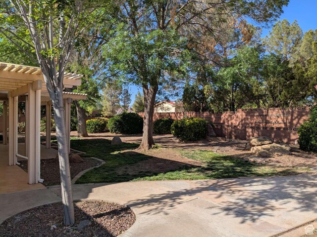 view of yard featuring a pergola, a patio area, and fence