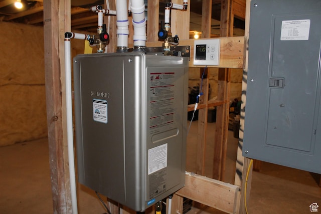 utility room featuring electric panel and water heater
