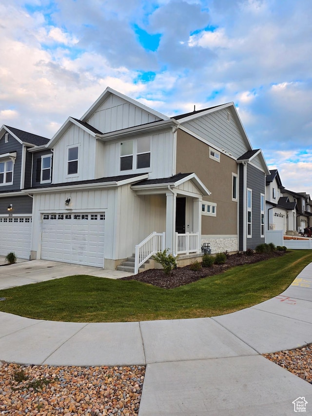view of front facade with an attached garage, board and batten siding, a front yard, and driveway