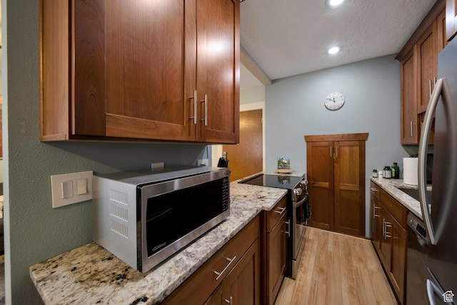 125 E 1st Ave Unit 206, Salt Lake City, UT 84103 - kitchen with stainless steel appliances, light wood finished floors, light stone countertops, recessed lighting, and brown cabinetry