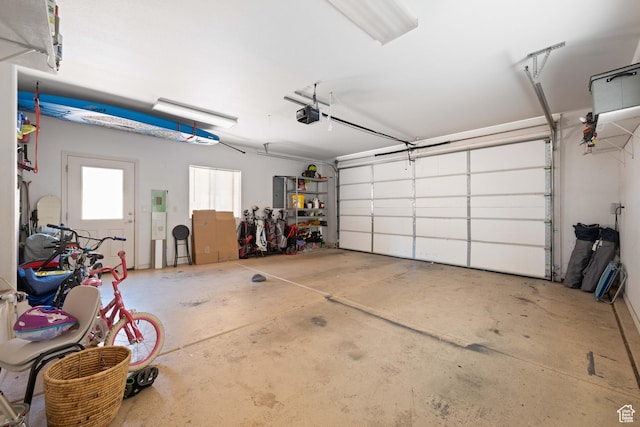 garage with a garage door opener and electric panel