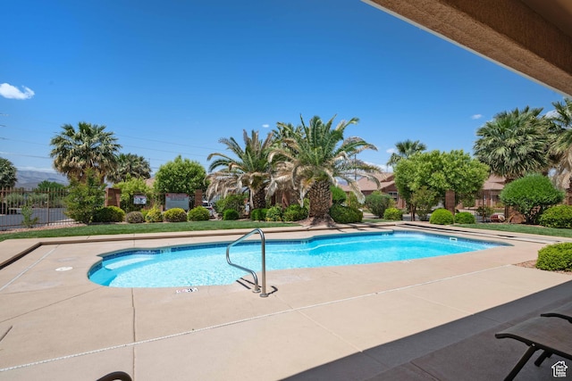 community pool with fence and a patio