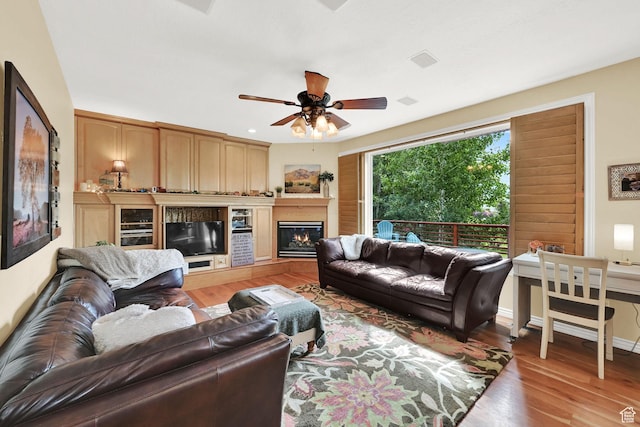 857 E 3250 N, North Ogden, UT 84414 - living area featuring light wood-type flooring, a ceiling fan, and a warm lit fireplace