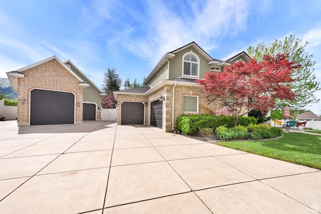 857 E 3250 N, North Ogden, UT 84414 - traditional-style house with concrete driveway, an attached garage, brick siding, a front lawn, and stucco siding