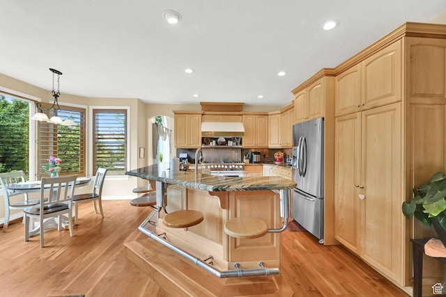 857 E 3250 N, North Ogden, UT 84414 - kitchen featuring stainless steel fridge, light brown cabinetry, light wood-type flooring, stone counters, and a breakfast bar area