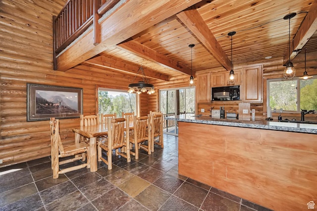 kitchen with black microwave, beam ceiling, wooden ceiling, dark stone countertops, and stone tile floors