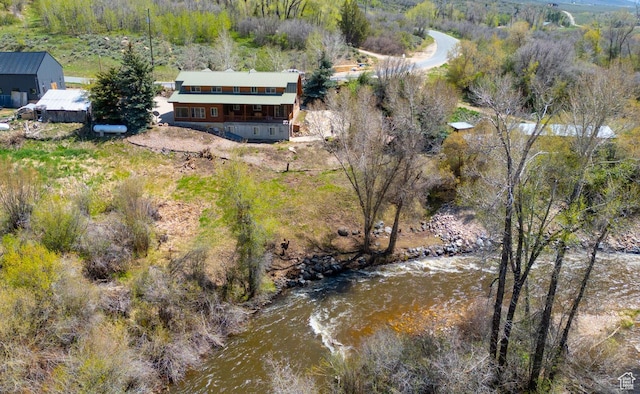 aerial view of property and surrounding area featuring a heavily wooded area