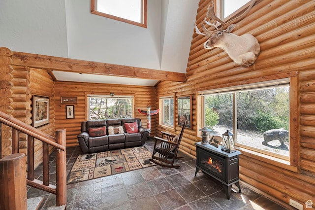 living room featuring a high ceiling, a wood stove, log walls, stairs, and dark stone finish flooring
