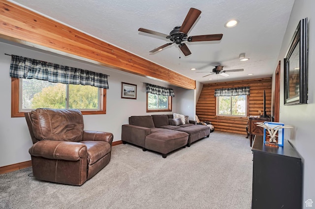 carpeted living area with rustic walls, recessed lighting, baseboards, ceiling fan, and a textured ceiling