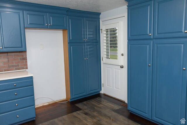 135 N 3rd E, Preston, ID 83263 - kitchen with blue cabinets, decorative backsplash, light countertops, dark wood-style floors, and a textured ceiling