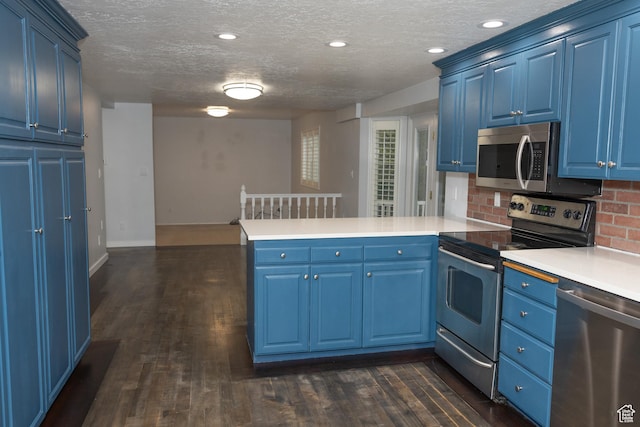 135 N 3rd E, Preston, ID 83263 - kitchen featuring stainless steel appliances, a peninsula, blue cabinetry, dark wood-type flooring, and a textured ceiling