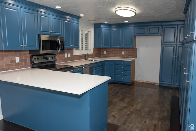 135 N 3rd E, Preston, ID 83263 - kitchen featuring appliances with stainless steel finishes, blue cabinetry, a peninsula, a sink, and a textured ceiling