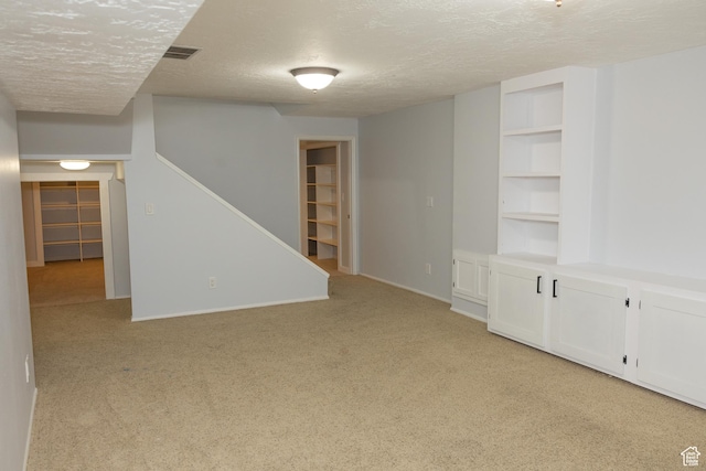 135 N 3rd E, Preston, ID 83263 - finished below grade area with a textured ceiling, light colored carpet, stairway, built in shelves, and baseboards