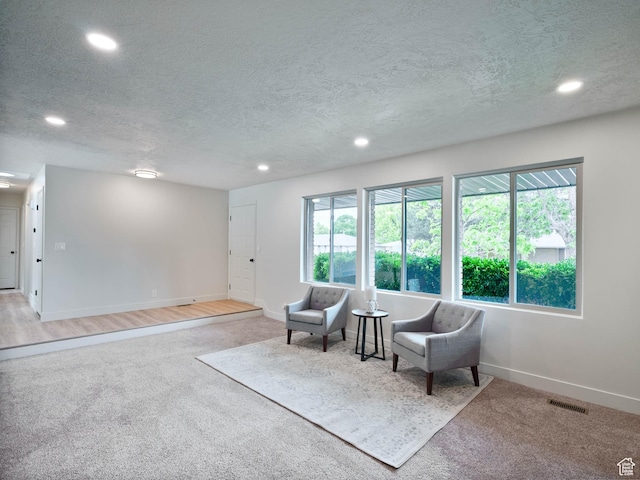 sitting room featuring recessed lighting, carpet floors, baseboards, and a textured ceiling