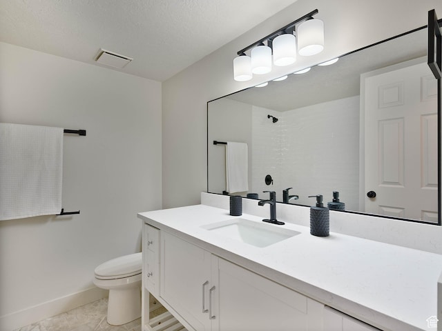 bathroom with toilet, vanity, a shower, and baseboards