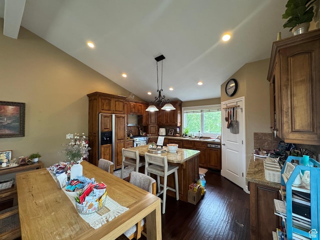 kitchen featuring paneled fridge, a sink, a center island, dark wood-style flooring, and recessed lighting