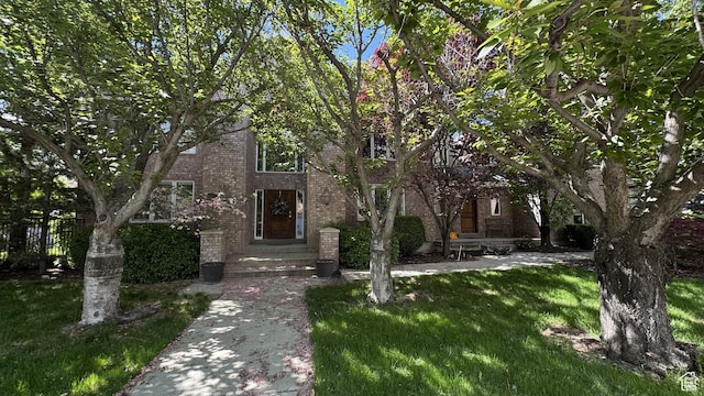 view of front of house featuring brick siding and a front lawn