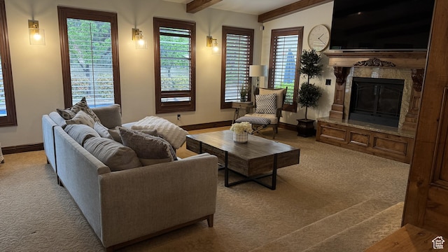 carpeted living area with baseboards, beamed ceiling, and a fireplace
