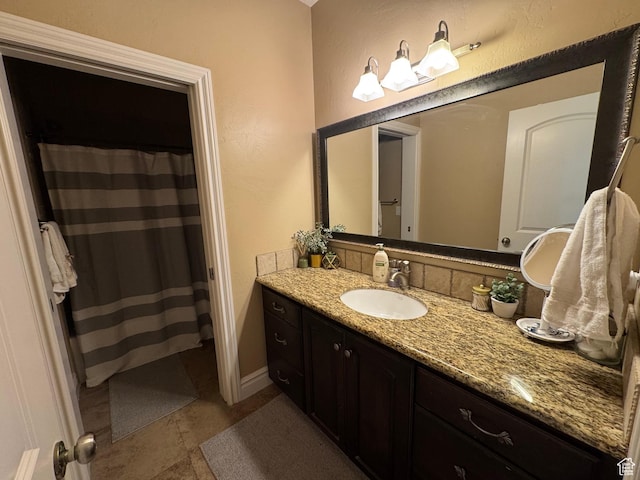 bathroom featuring vanity, curtained shower, and baseboards