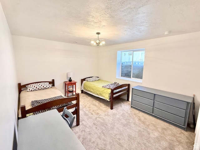 bedroom with carpet, a textured ceiling, and a chandelier