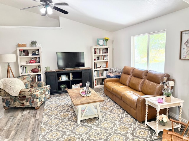 living room featuring lofted ceiling, wood finished floors, and a ceiling fan