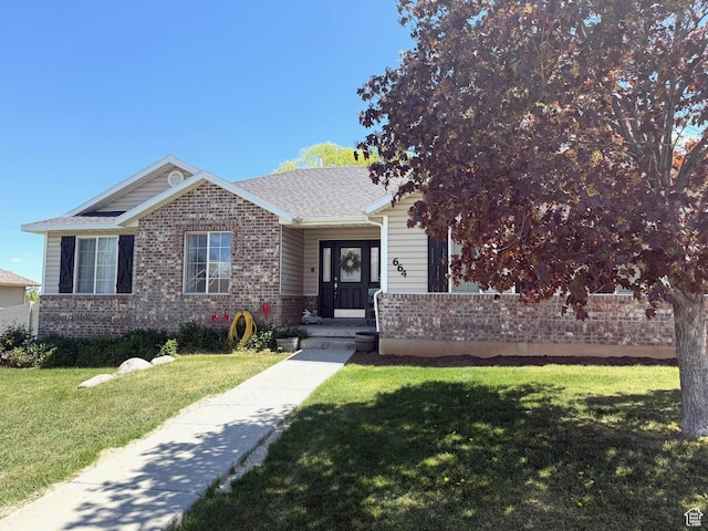 view of front of house featuring brick siding and a front lawn