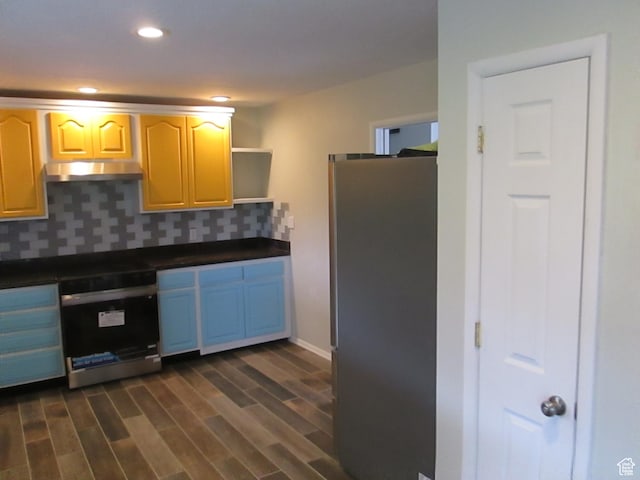 4872 N Burch Creek Dr, South Ogden, UT 84403 - kitchen with freestanding refrigerator, under cabinet range hood, dark countertops, wall oven, and tasteful backsplash