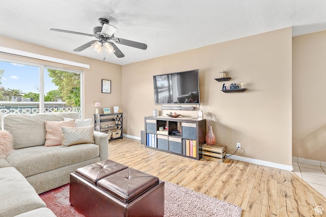 living room with baseboards, wood finished floors, and ceiling fan