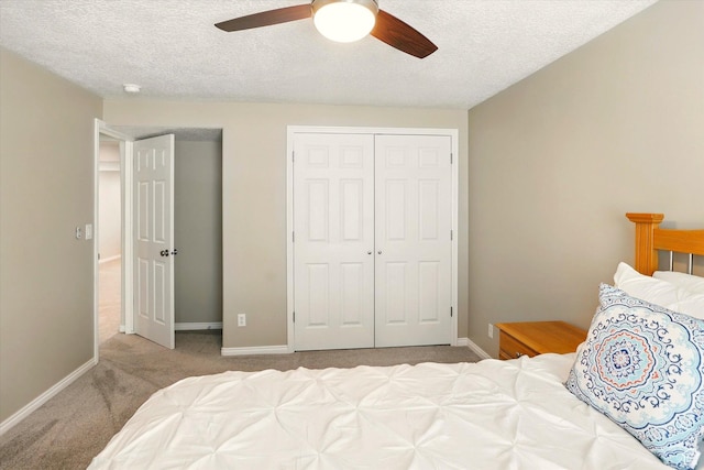 bedroom with carpet, a closet, a textured ceiling, baseboards, and ceiling fan