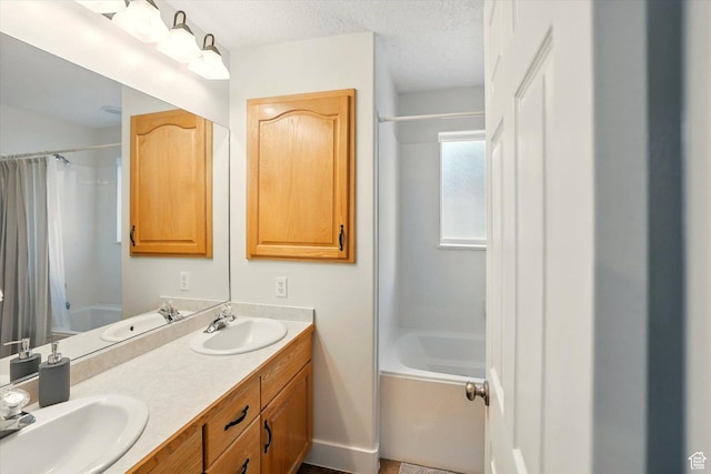 bathroom featuring shower / tub combo, double vanity, and a textured ceiling