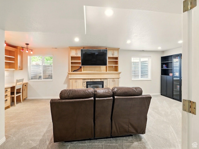 living area featuring carpet floors, baseboards, a glass covered fireplace, and recessed lighting