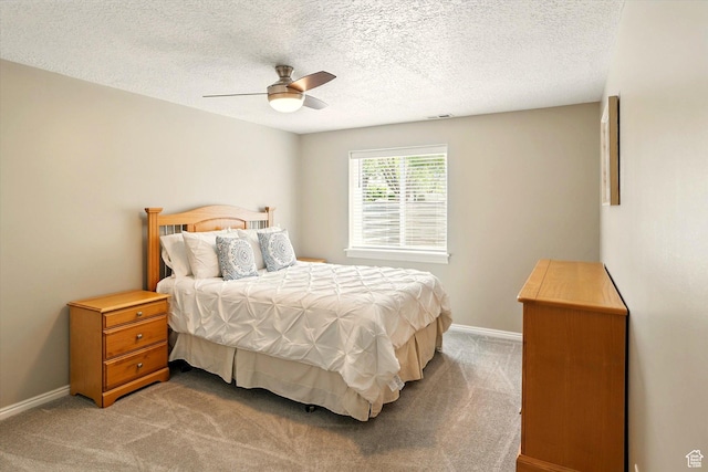 bedroom with carpet, a textured ceiling, baseboards, and a ceiling fan