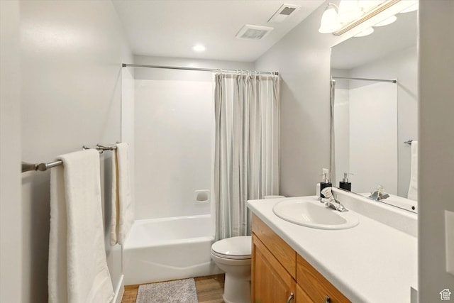 full bath with wood finished floors, toilet, shower / bath combo with shower curtain, and vanity