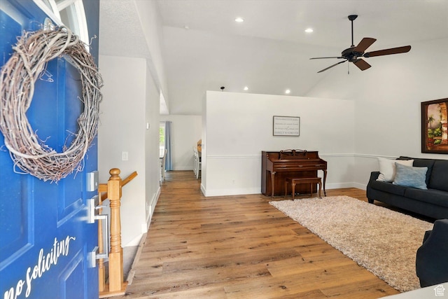living area with a ceiling fan, high vaulted ceiling, recessed lighting, wood finished floors, and baseboards