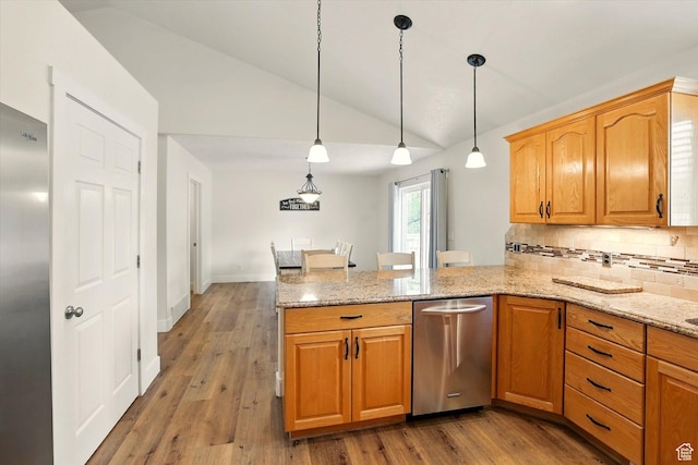 kitchen featuring a peninsula, lofted ceiling, stainless steel appliances, backsplash, and light stone countertops