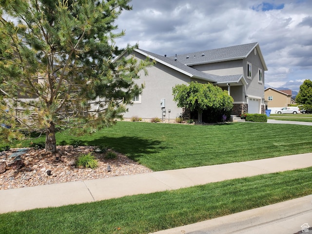 view of home's exterior featuring stucco siding, an attached garage, stone siding, a yard, and roof with shingles