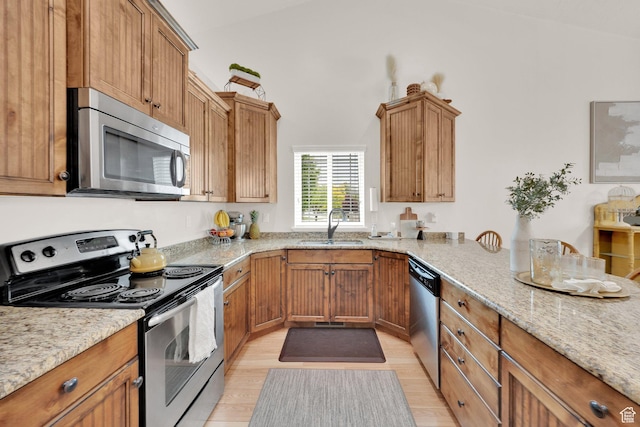 616 W Northlake Dr, Lehi, UT 84043 - kitchen with stainless steel appliances, a sink, light stone countertops, light wood-style flooring, and brown cabinetry
