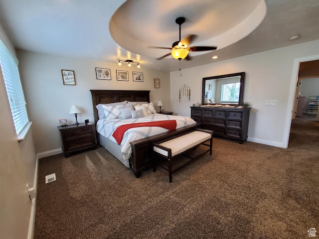 bedroom with multiple windows, dark colored carpet, baseboards, and ceiling fan