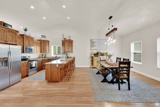 616 W Northlake Dr, Lehi, UT 84043 - kitchen with appliances with stainless steel finishes, brown cabinets, a peninsula, a kitchen bar, and recessed lighting