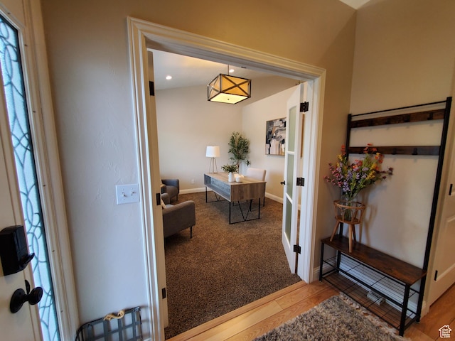 foyer entrance with wood finished floors, baseboards, french doors, and carpet