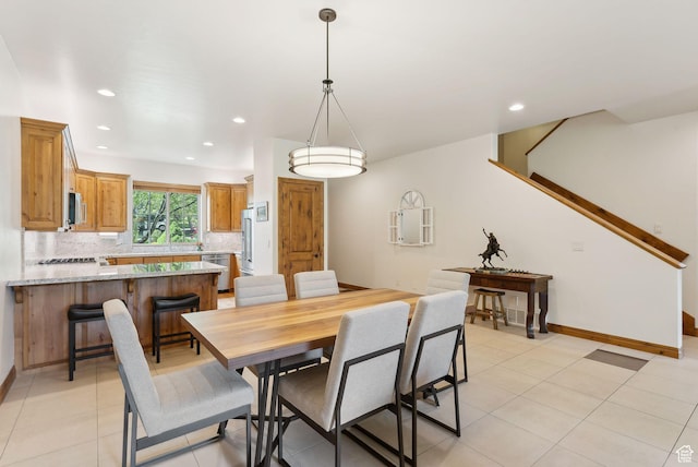 dining space featuring recessed lighting, light tile patterned floors, and baseboards