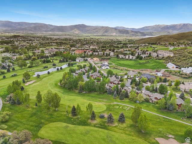 aerial overview of property's location featuring nearby suburban area, a golf course, and a water and mountain view